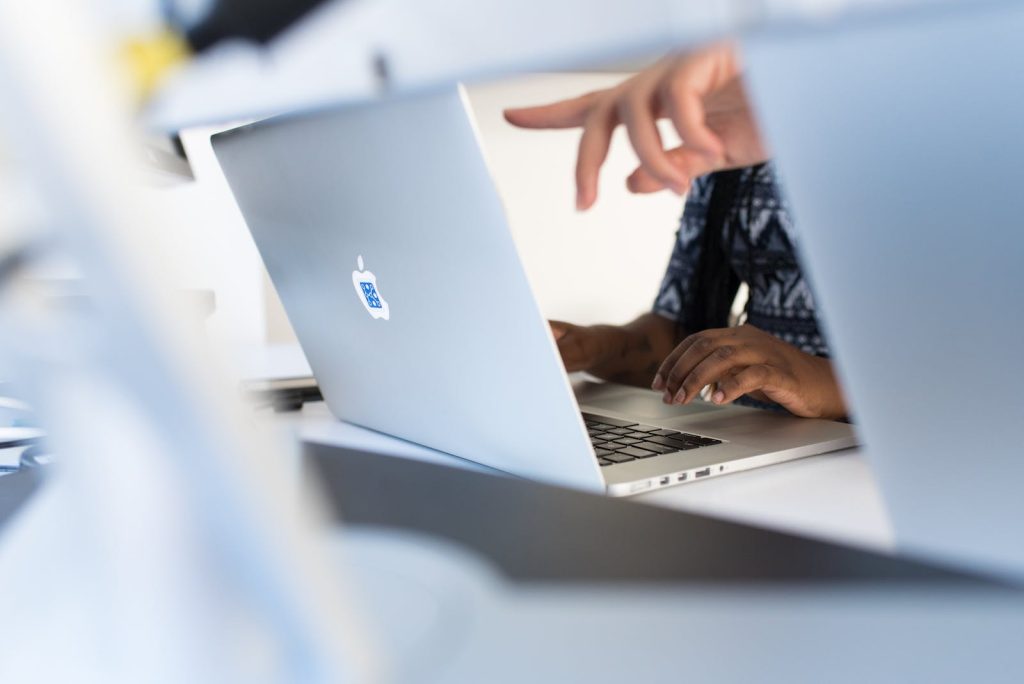 laptop brand comparisons - person pointing at a mac laptop