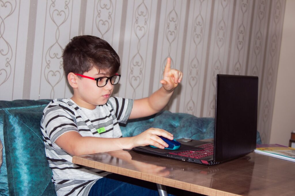 good laptop for kids - young boy using laptop