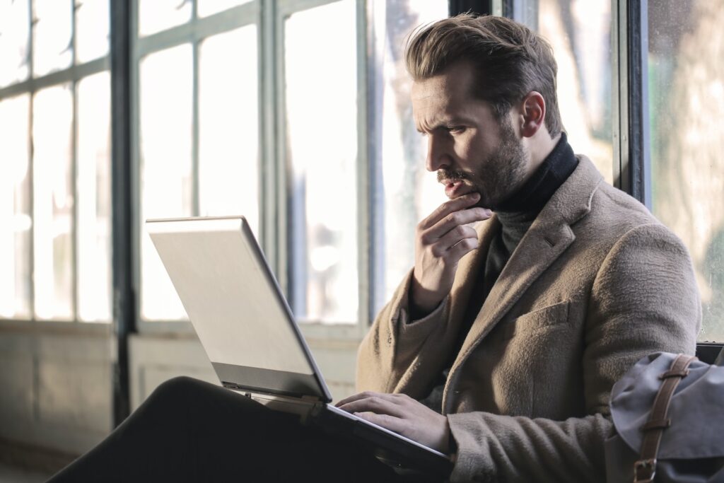 Q&A Lenovo vs HP laptops - man holding his chin facing laptop computer